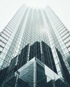 Striking low angle view of a modern skyscraper with reflective glass facade in a cityscape.