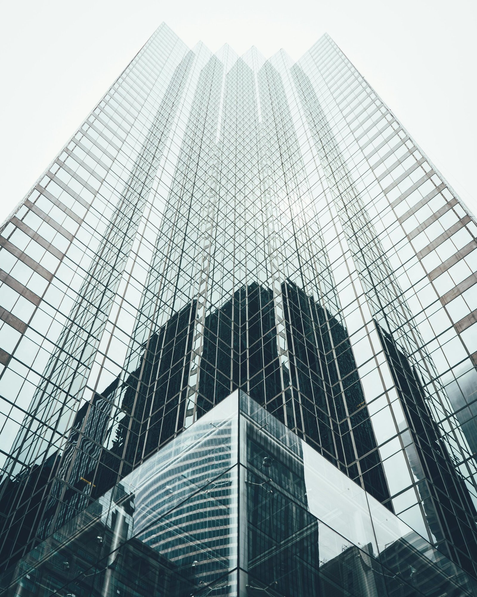 Striking low angle view of a modern skyscraper with reflective glass facade in a cityscape.